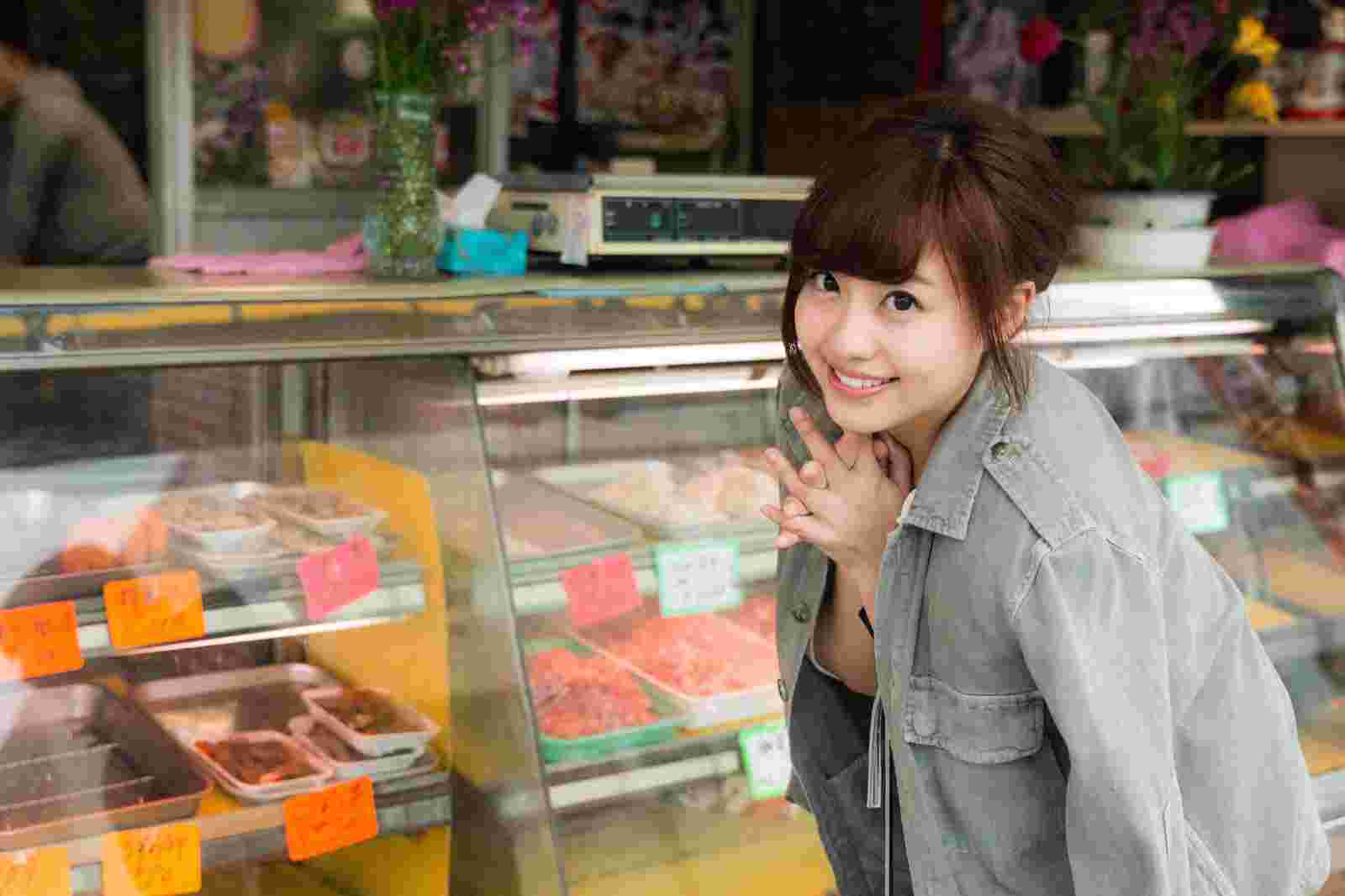 精肉店のショーケースの前で笑顔の女性