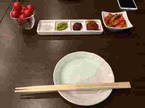 テーブルにあるトマトとキムチと薬味