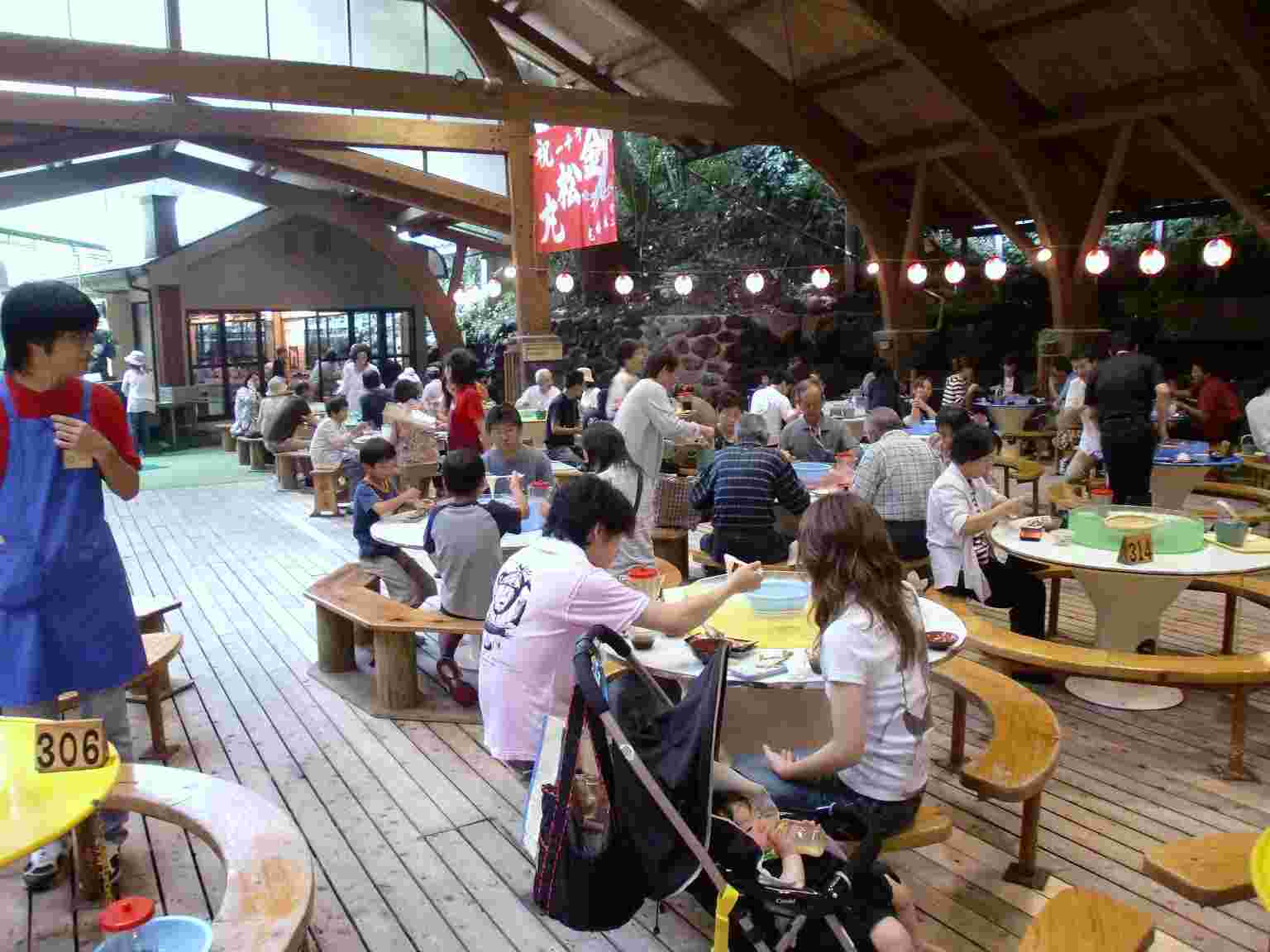 冷たくて美味しいそうめん流しを愉しむ人々でいっぱいの開放的な店内