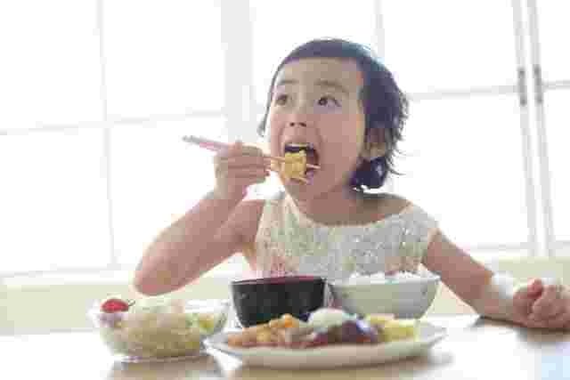 美味しそうに朝食を食べる子供