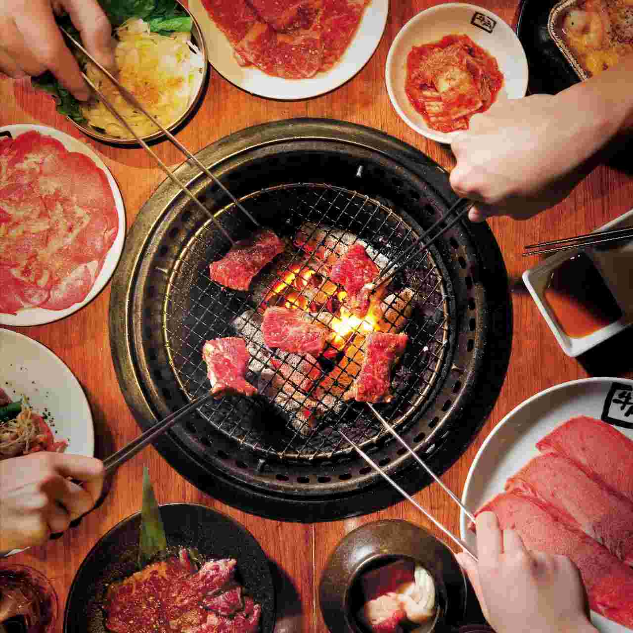 大人数で焼肉を焼いている