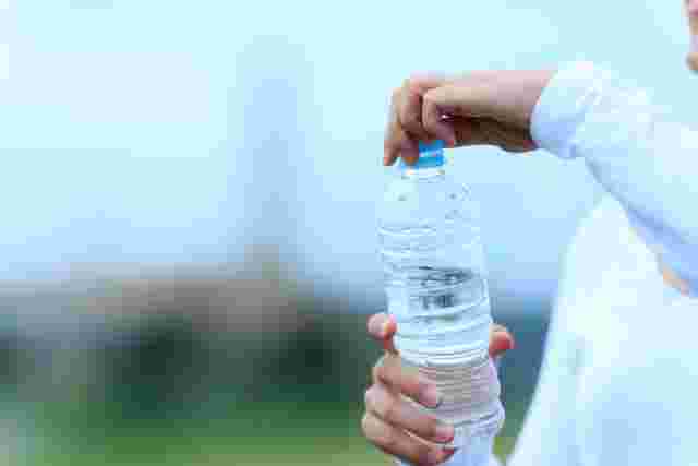 ペットボトルの水の蓋を閉めている様子