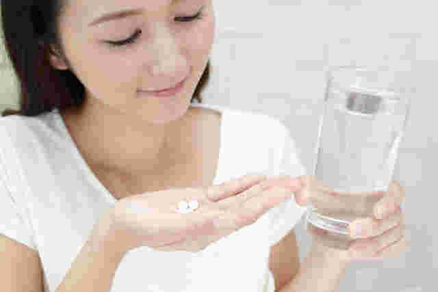 お水とサプリメントを持っている人の画像