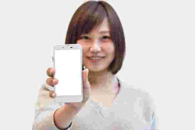 スマホの画面を見せる女性