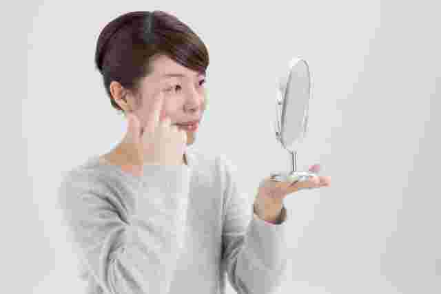 肌のしみやしわをチェックしている女性