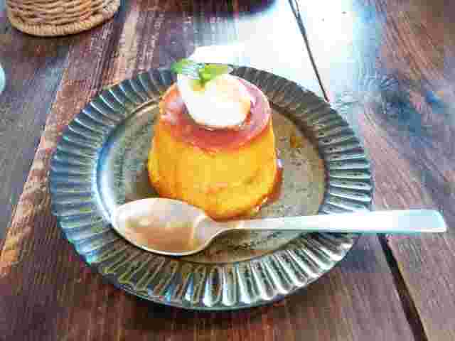 お皿にのせてスプーンを添え、生クリームを乗せたプリン