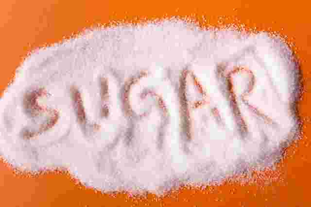 オレンジ色の背景にグラニュー糖が散りばめてあり、その上からsugarと指でなぞった跡がある