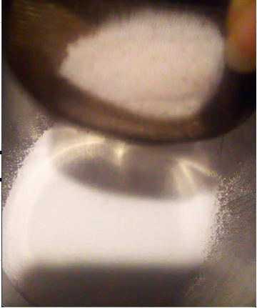茶漉しで細かくした粉砂糖をふるいにかけている写真