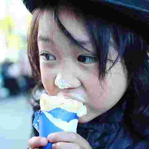 生クリームたっぷりのクレープを頬張る女の子