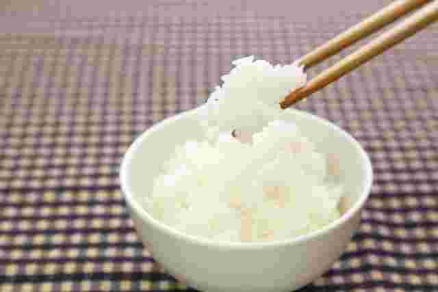 茶碗に盛られたご飯を箸で持ち上げている様子