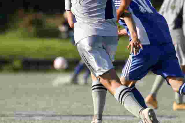 サッカーで走り回る男性