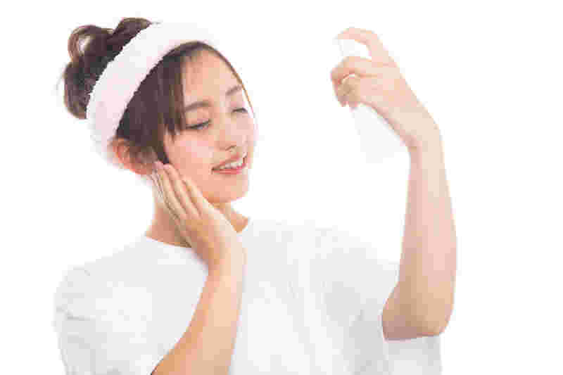 化粧水をスプレーしている女性