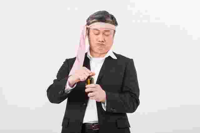 頭にネクタイを巻いてキャップを開けようとする男性