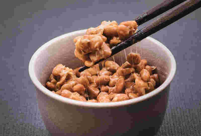 箸で納豆をつかんでいる