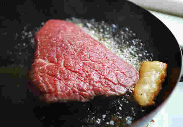 ステーキ肉を焼いている様子