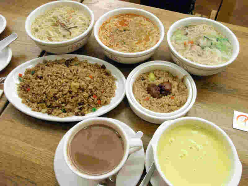 テーブルに並べられたミスドの飲茶らーめん3種類、黒チャーハン、中華おこわ、ホットチョコレート、コーンスープ