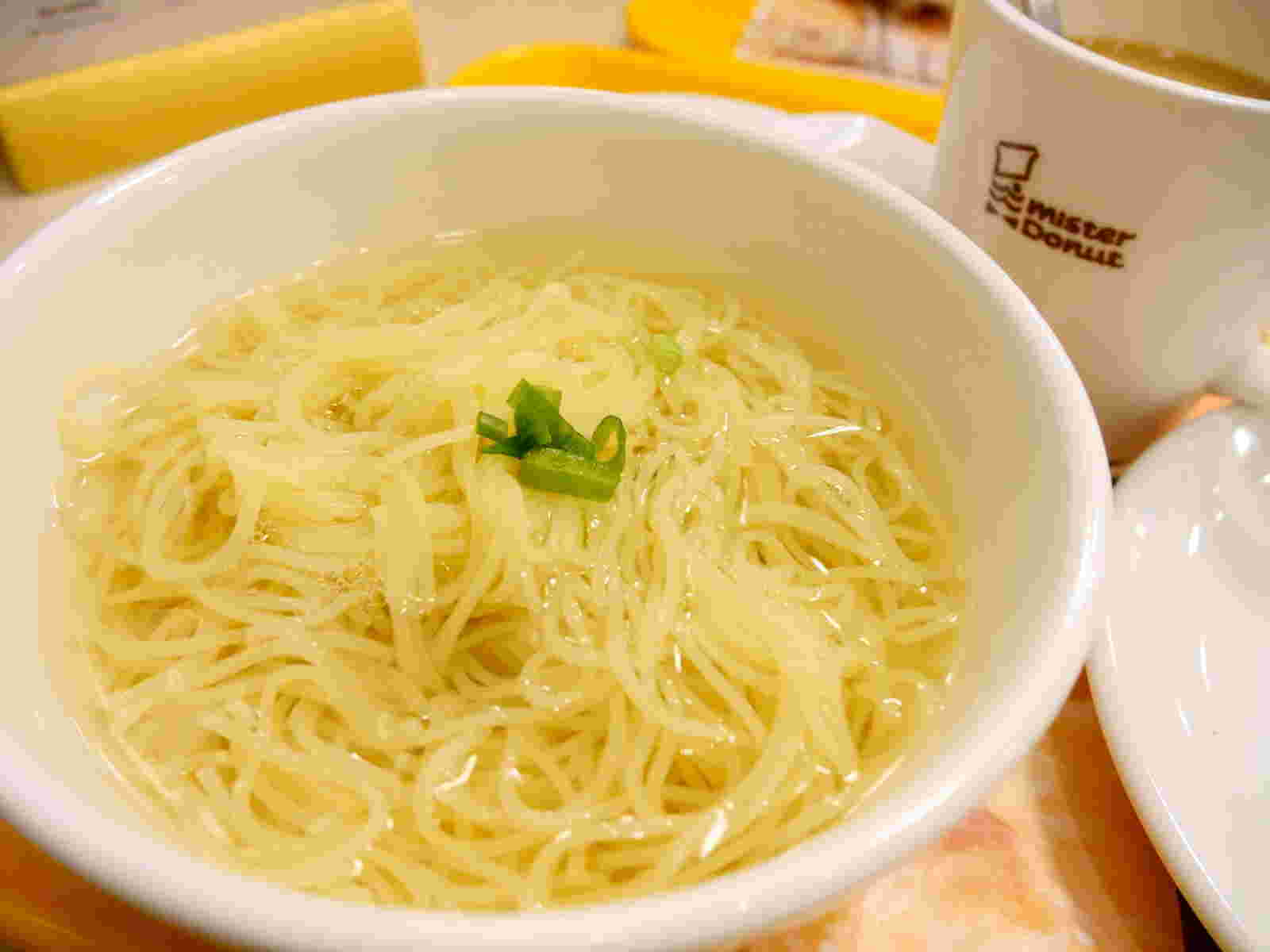 白いドンブリに入った透明のスープのミスドの汁そば
