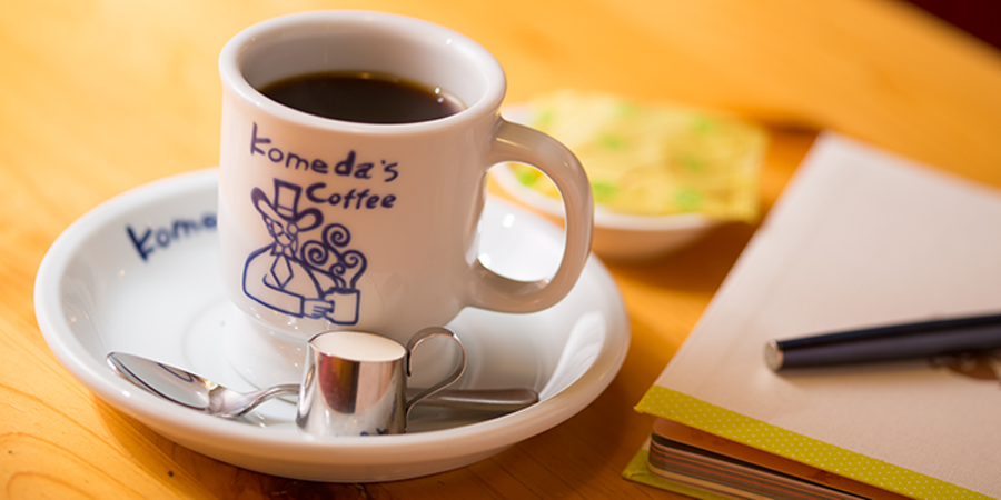 テーブルの上にコーヒーカップと書類がのっている