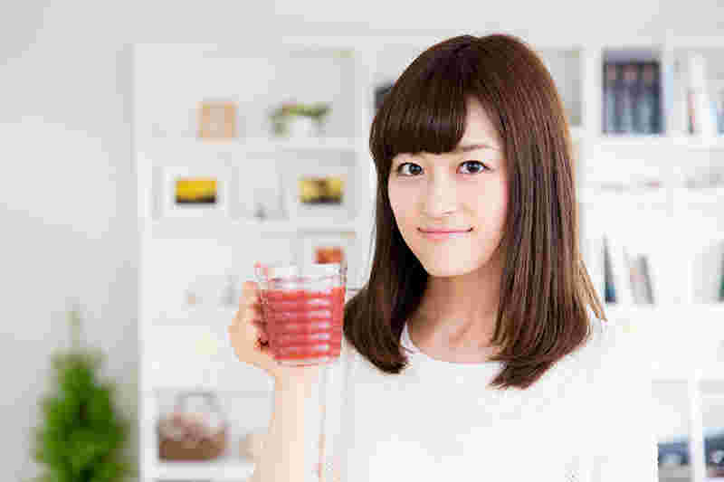トマトジュースを持っている女性