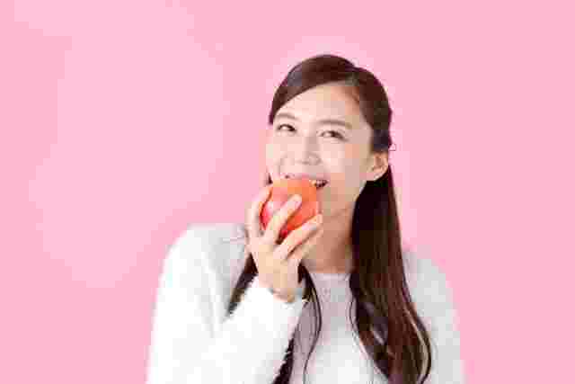 りんごを皮ごと食べる女性