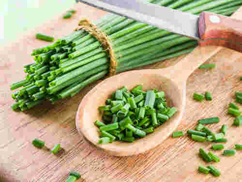 香味野菜の小口ねぎをまな板の上でみじん切りにしてスプーンですくう