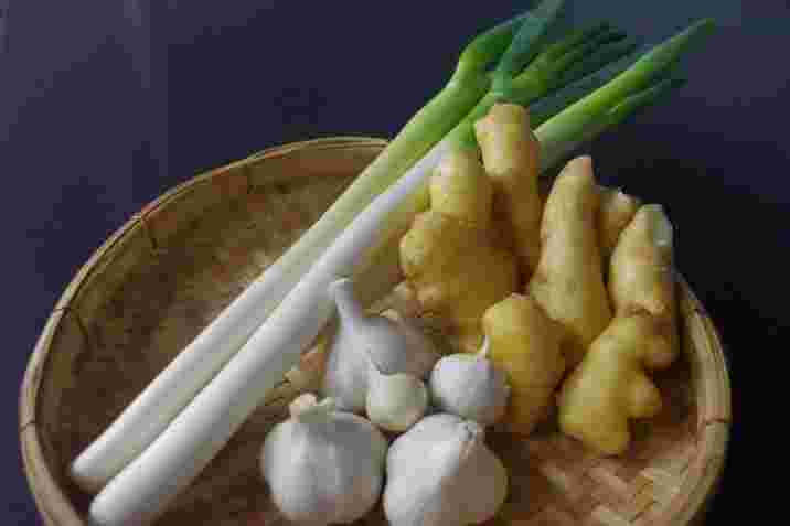 香味野菜のねぎ、にんにく、しょうがをざるに盛る