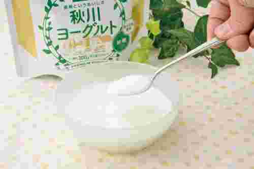 秋川牧園のプレミアムヨーグルト（加糖）を器に入れてスプーンですくう