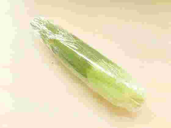 皮つきのとうもろこしをラップで包む