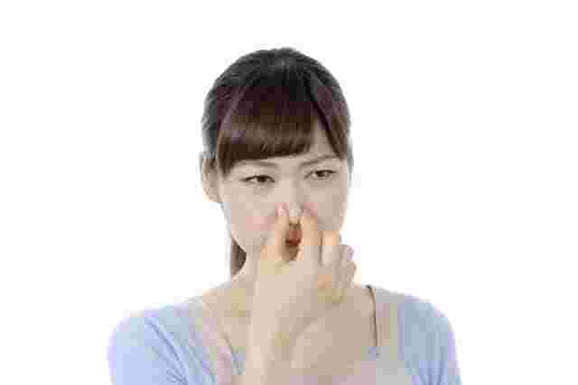 鼻をつまんでいる女性