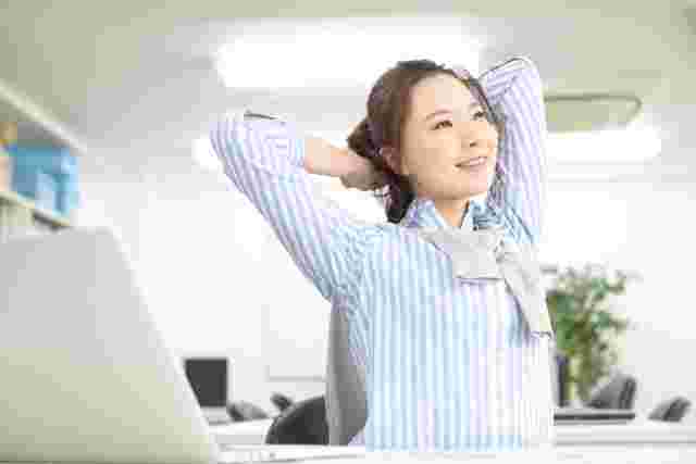 伸びをするオフィスの女性