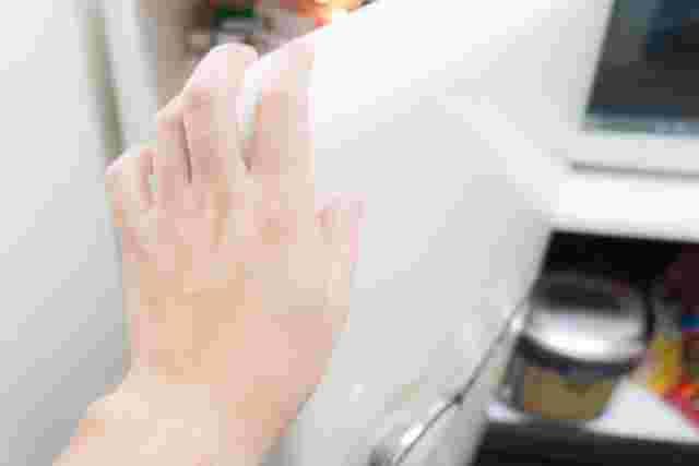 冷蔵庫のドアを閉めようとしているところ