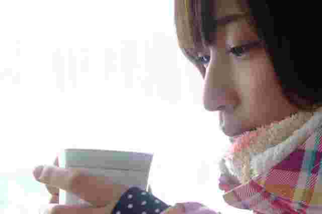 寒そうにマグカップをもつ女性