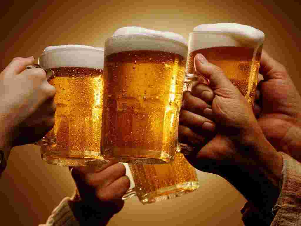 ビールジョッキを持って4人で乾杯している様子