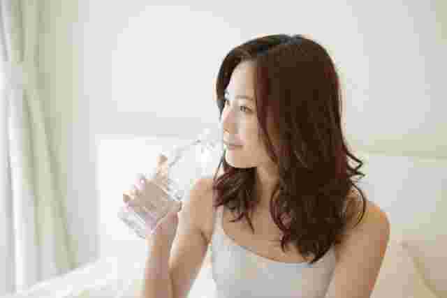 ペットボトル飲料を飲んでいる女性