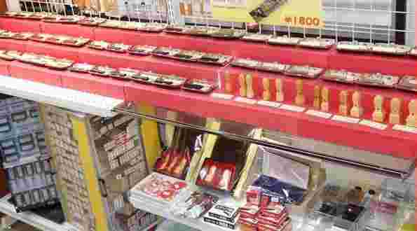 横長いショーケースの上の赤色の置台に沢山の印鑑、ショーケースの中にも印鑑、朱肉が綺麗に並べられている