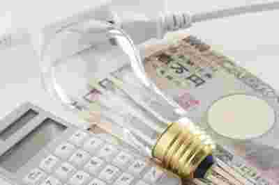 電球と電卓とお金の画像