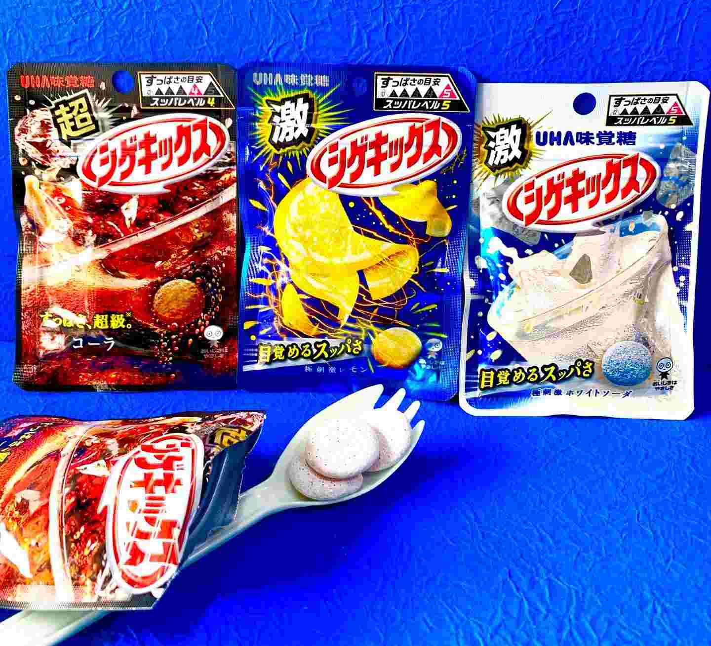 お菓子が4つ置かれている様子。そのうちの1つが封を開けてスプーンに中身が入っている様子。