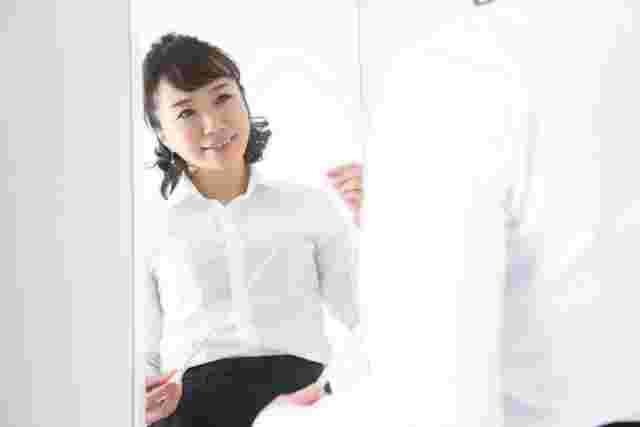 メジャーを持った女性が鏡の前に立っている様子