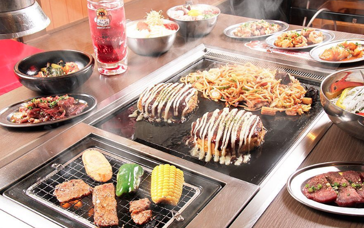 テーブルと鉄板にのっている食べ放題メニュー色々