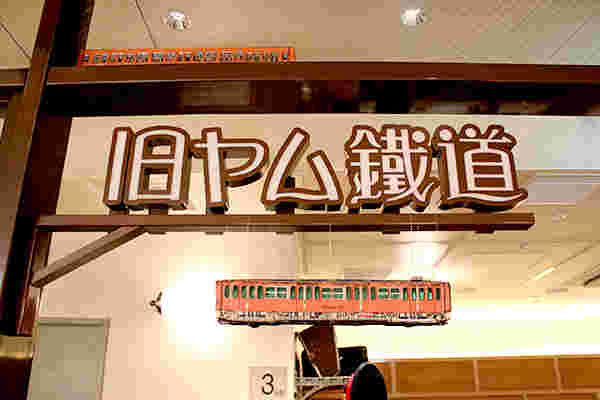 鐵道が吊り下げられた遊び心のあるお店の看板