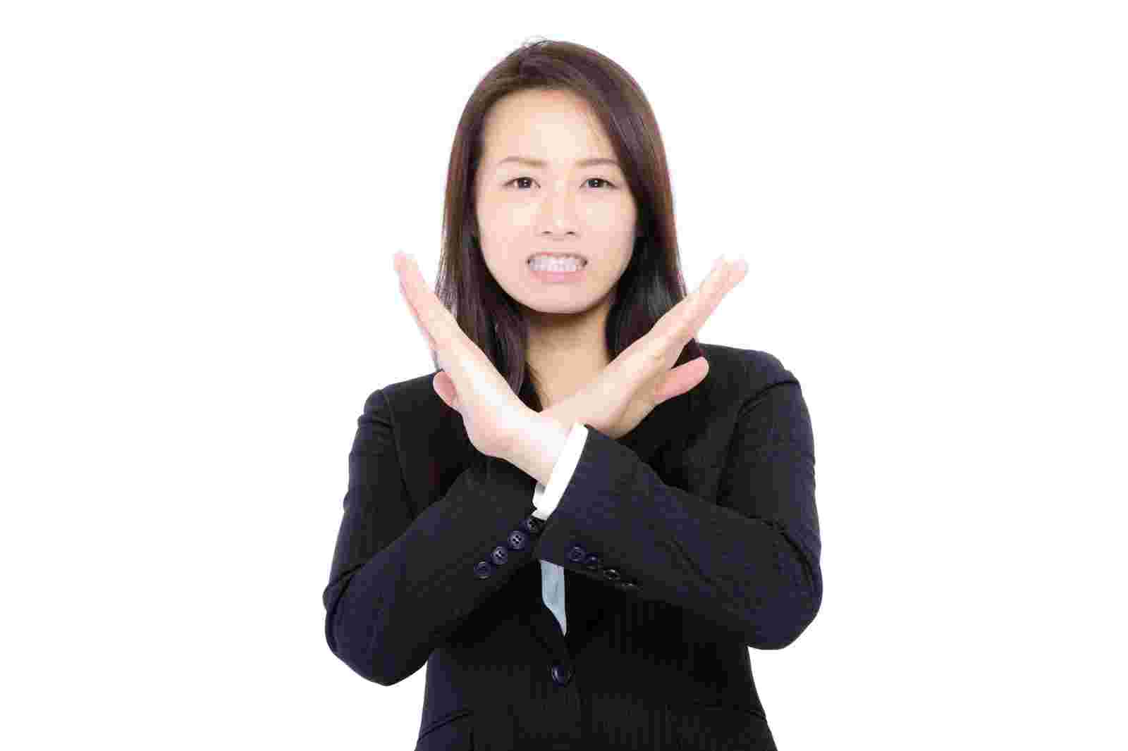 バツを示す女性