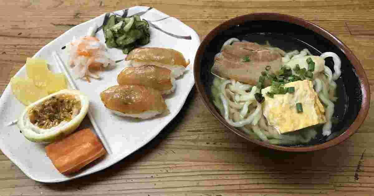 さわらの漬け寿司と副菜が一緒になったプレートと揚げがのったうどんが横に並んでいる様子