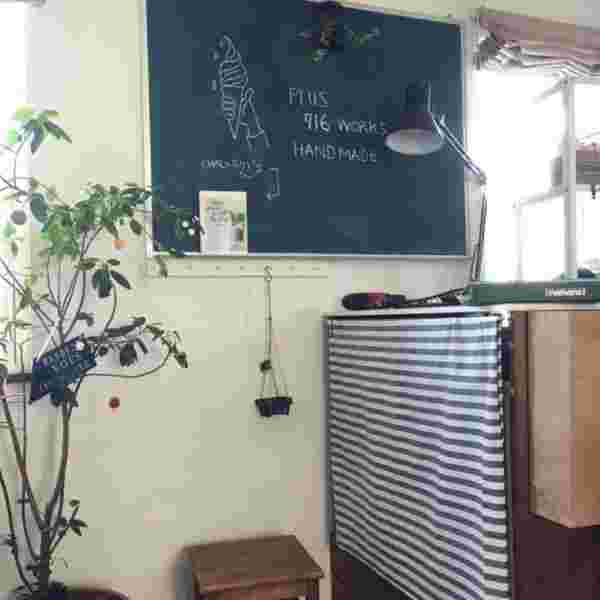 玄関に観葉植物と黒板が置いて有る様子。