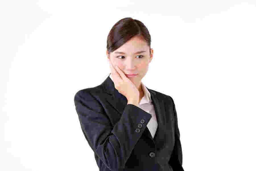手に頬を当て考え込む会社員の女性