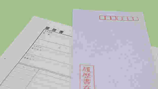 履歴書の上に履歴書入れが置かれている様子