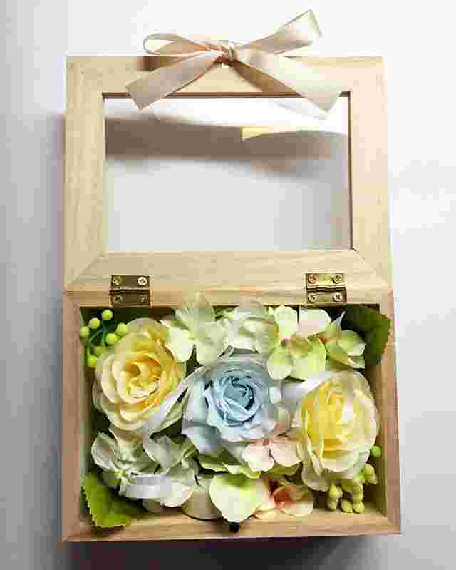 木製のフォトフレームに柔らかな色合いの花が敷き詰められた様子