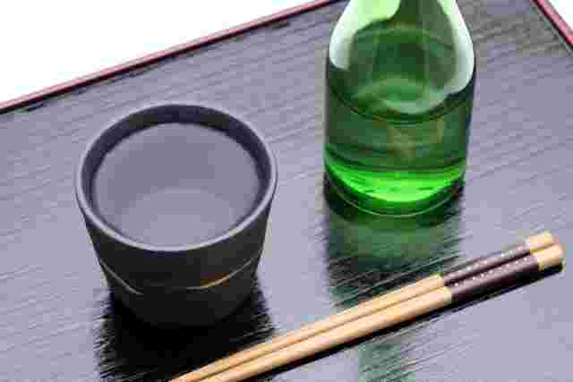 おちょこに入った焼酎と箸