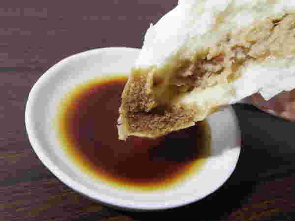 肉まんに酢醤油をつけている様子