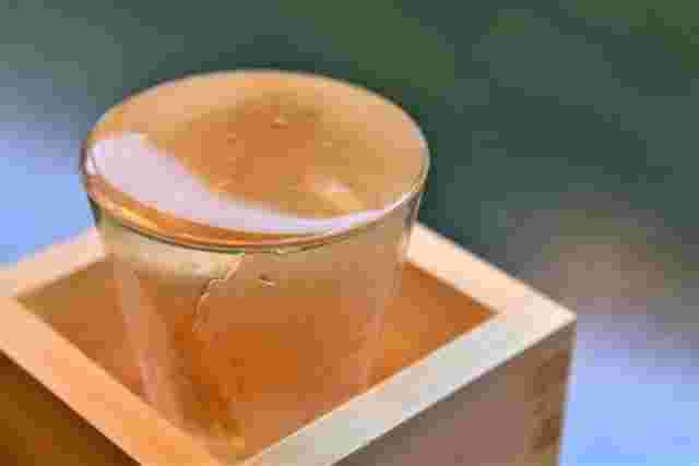 枡の中に日本酒の入ったグラスが置かれている