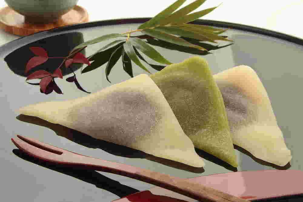 漆の器の上にニッキと抹茶のなまやつはしが3つ載っている